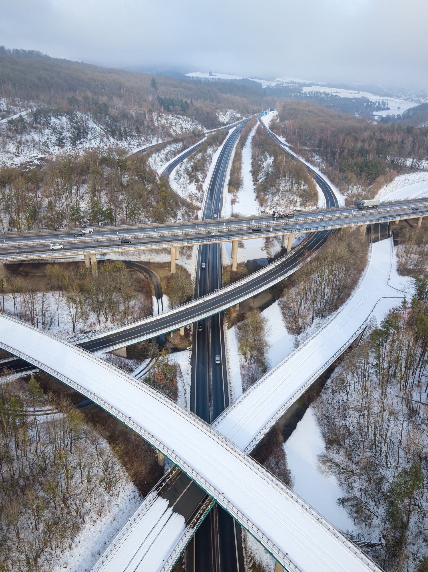 Aerial view of highway intersection in winter landscape with snow covered roads