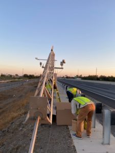 Workers mounting Road Weather station